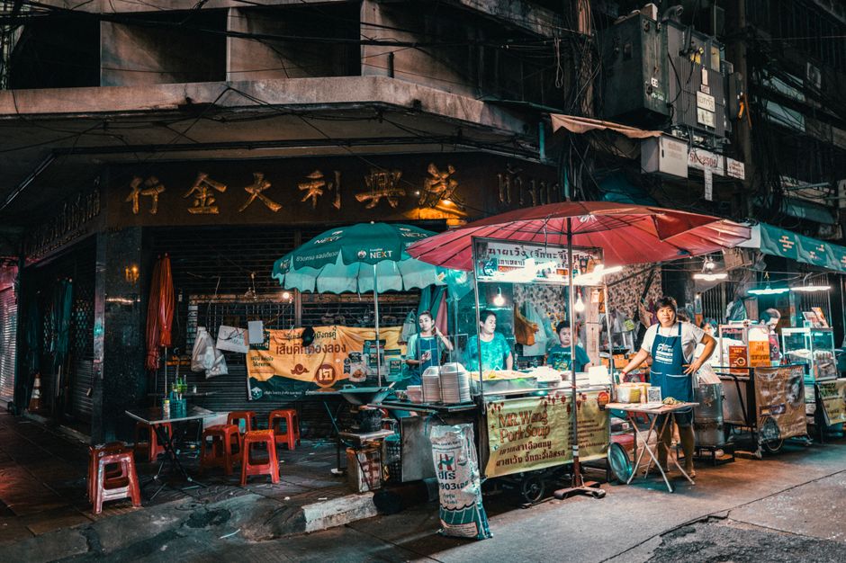 Vibrant night market scene in Bangkok showcasing street food vendors and bustling activity.